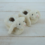 Pair of fluffy bunny slippers on a wooden surface