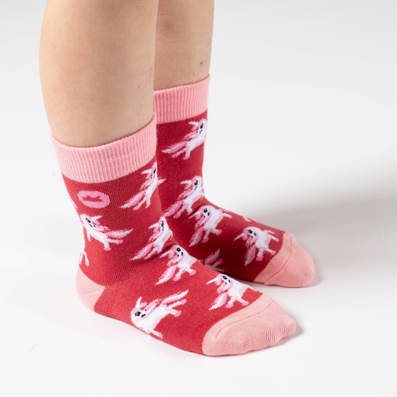 Red socks with white ghost patterns worn by a person on a white background